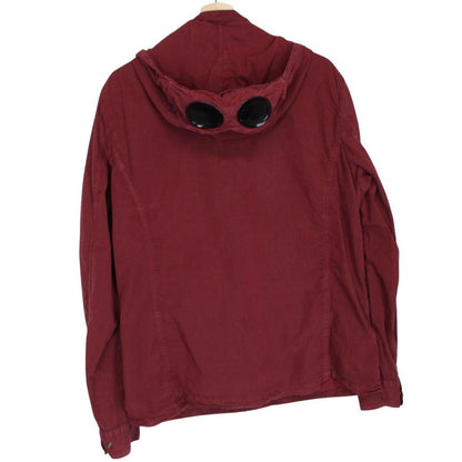 CP Company burgundy jacket with goggle detail and full zip closure.