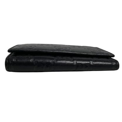 Gucci black leather key case featuring GG monogram pattern and scuffed details.