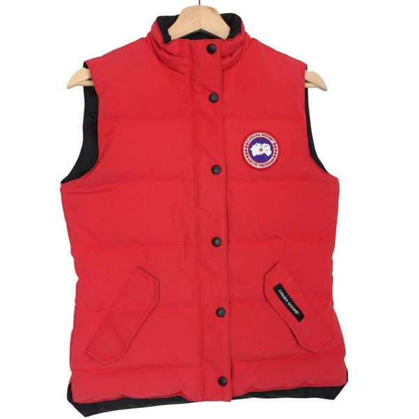 Canada Goose red down gilet with logo patch and zippered pockets.