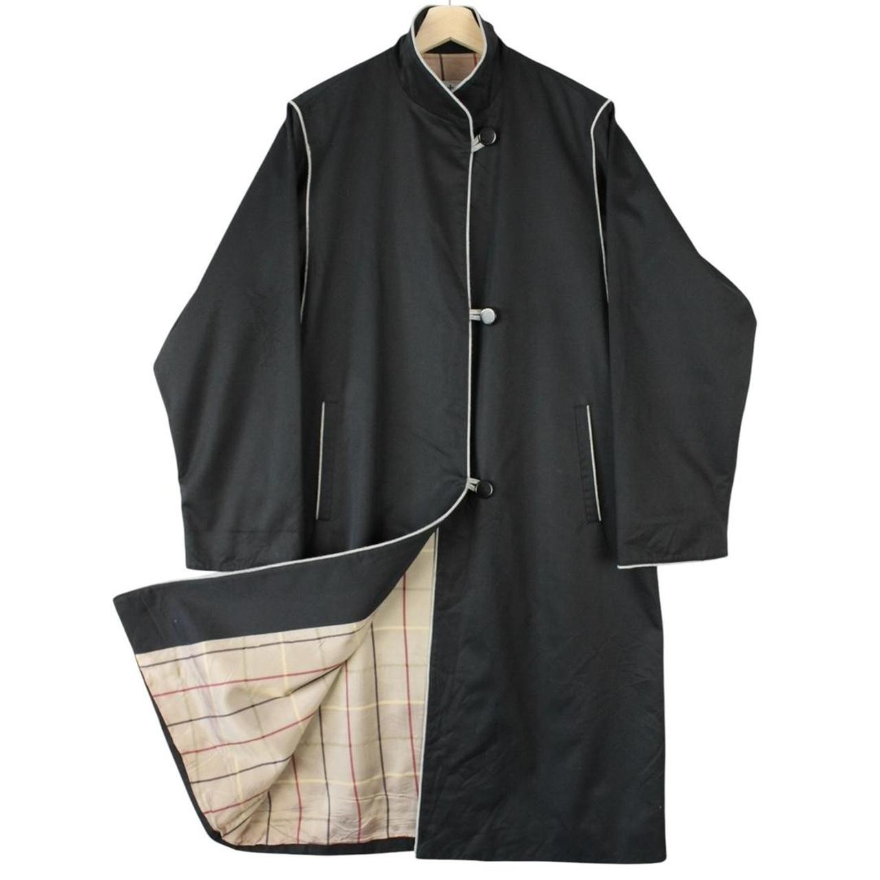 Burberry black cotton trench coat with single breasted design and classic logo detailing.