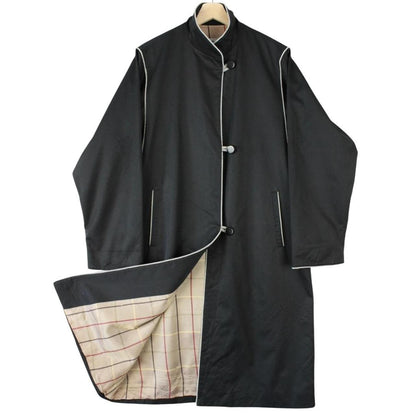 Burberry black cotton trench coat with single breasted design and classic logo detailing.
