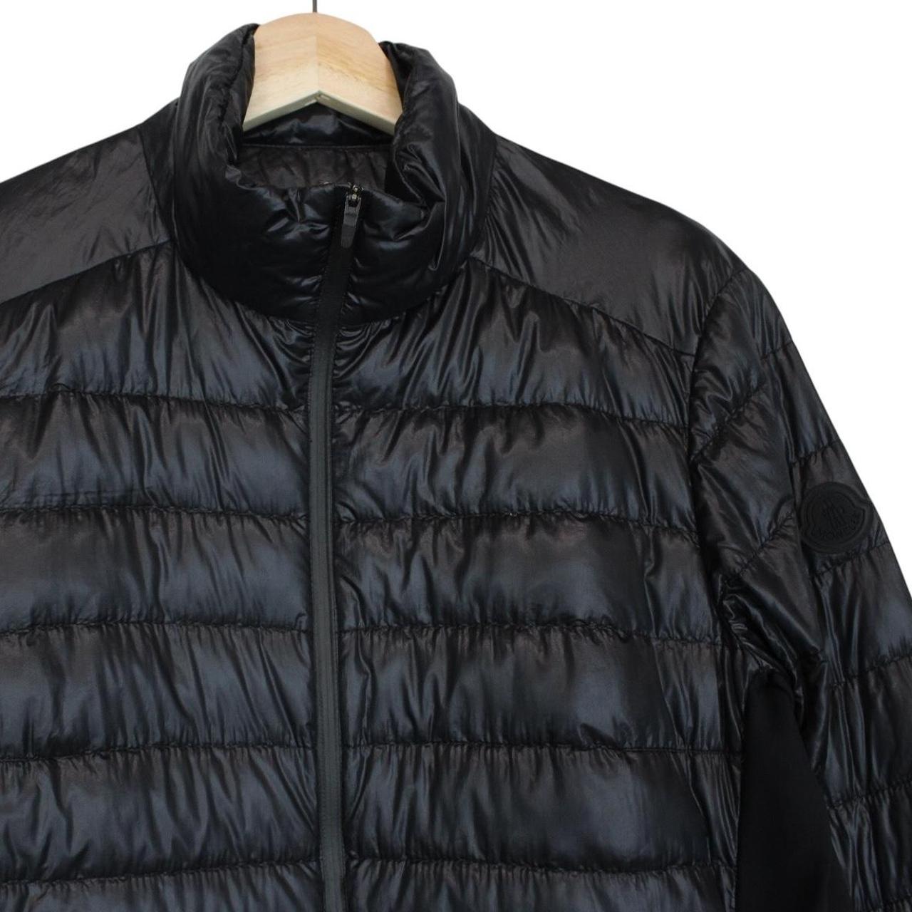 Moncler black lightweight down jacket with full zip and logo patch on sleeve.