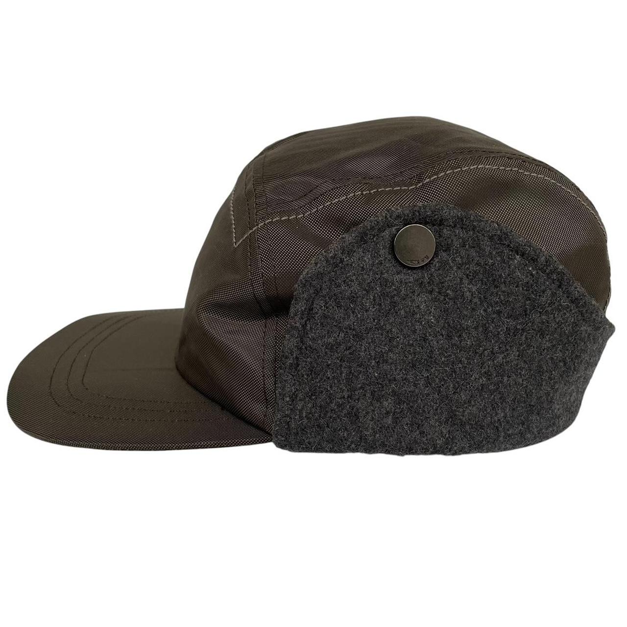 Paul Smith khaki green nylon ear-flap cap with logo detail and adjustable straps.