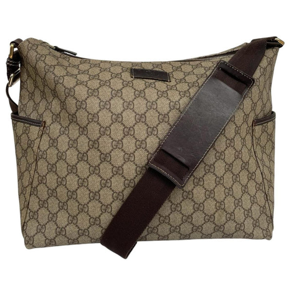 Gucci brown diaper changing bag with Supreme GG monogram and leather shoulder strap.