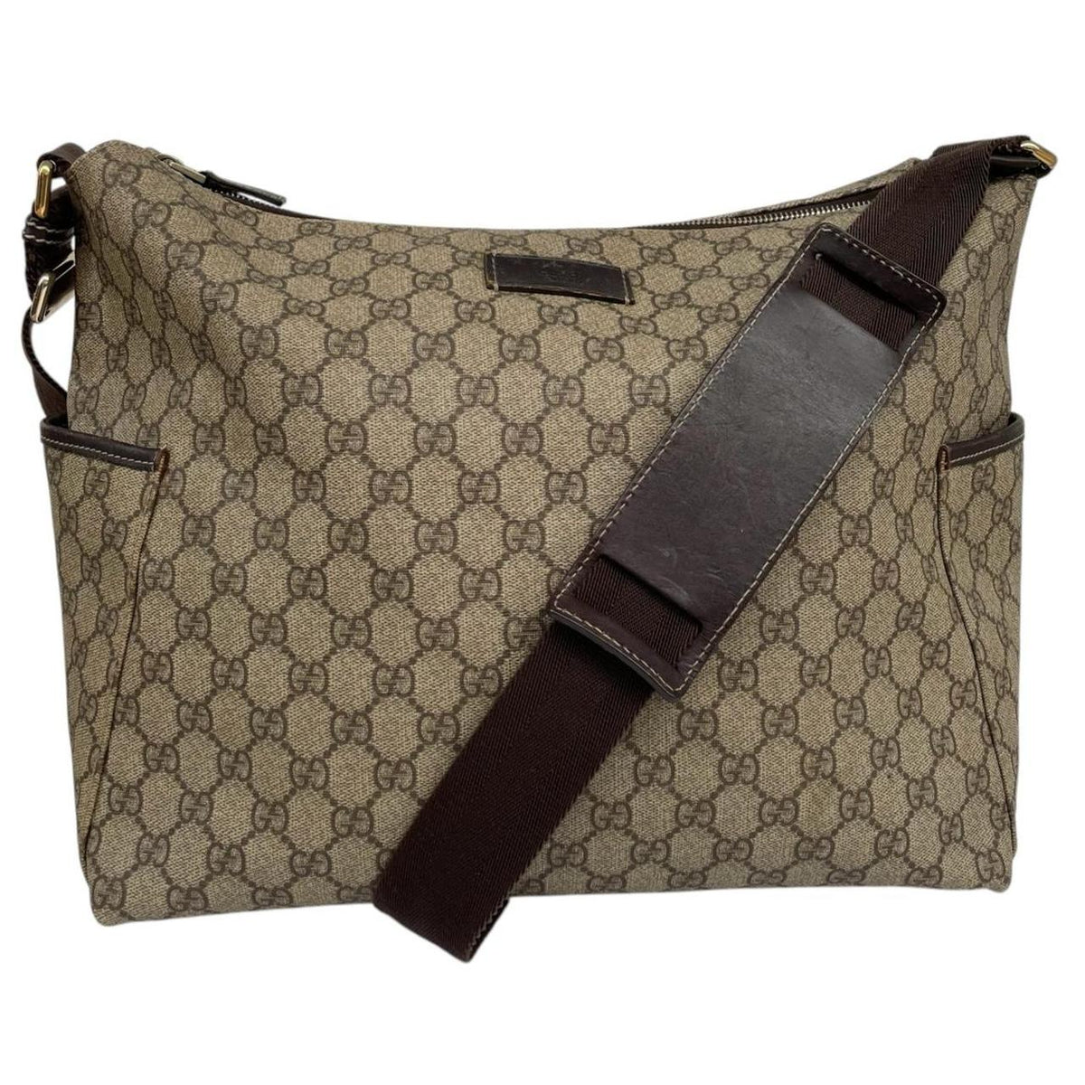 Gucci brown diaper changing bag with Supreme GG monogram and leather shoulder strap.