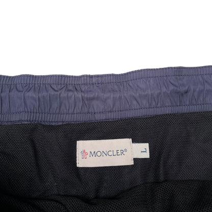 Moncler navy blue swim shorts with logo patch and lightweight nylon material.