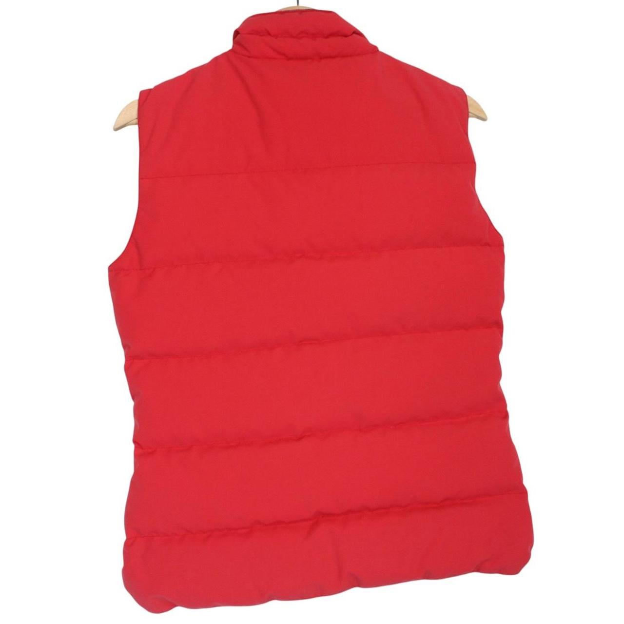 Canada Goose red down gilet with logo patch and zippered pockets.