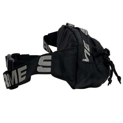 Supreme black waist bag featuring logo print and durable material.