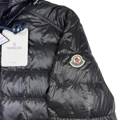 Moncler black hooded puffer jacket with logo patch and nylon material.