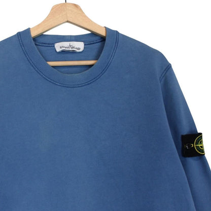 Stone Island blue cotton sweatshirt with logo patch and faded details.