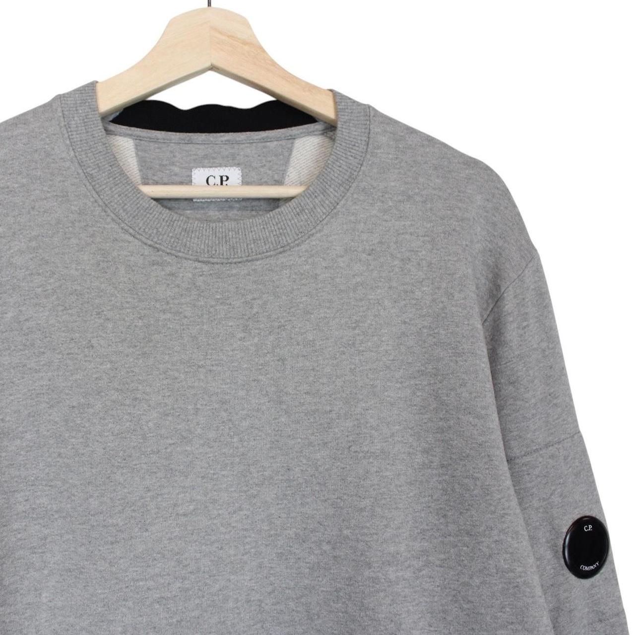 CP Company grey sweatshirt with lens detail and cotton material.