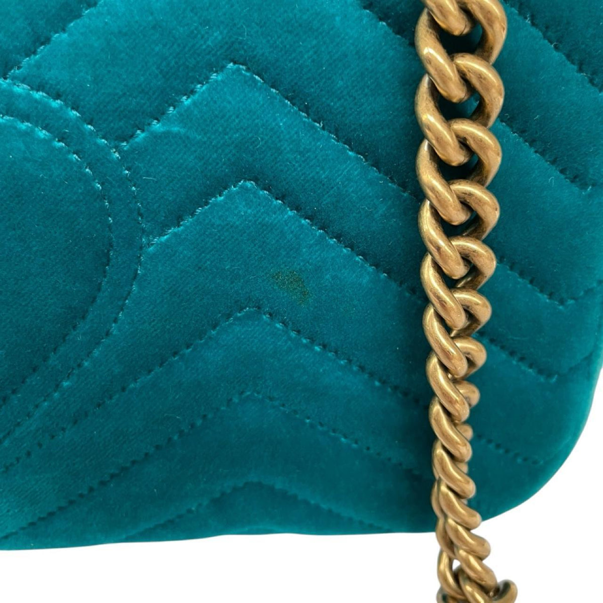 Gucci turquoise velvet shoulder bag with gold GG logo and green accents.