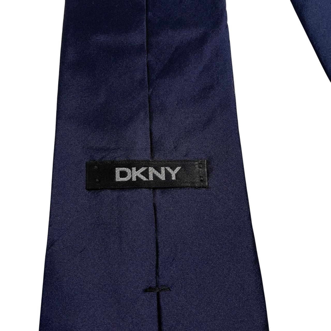 DKNY navy blue silk tie with subtle sheen and classic design.
