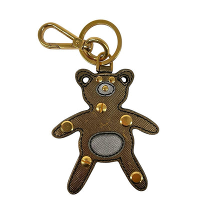Prada brown and gold teddy bear bag charm in Saffiano leather with logo detail.