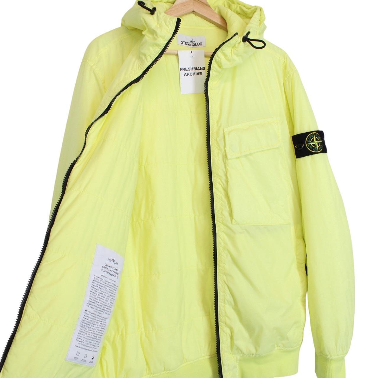 Stone Island yellow jacket with crinkle texture and logo badge on sleeve.