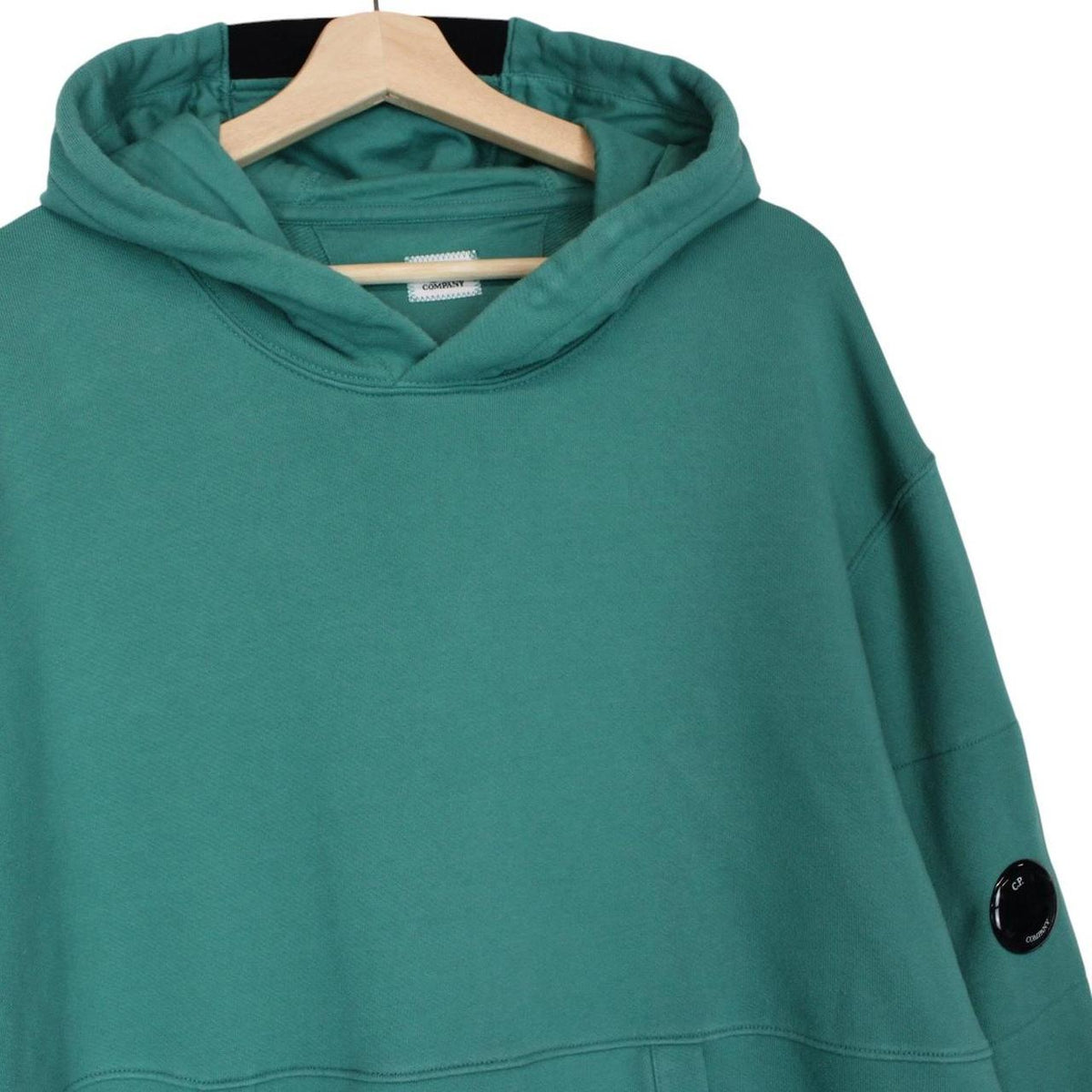CP Company green hoodie jumper with lens detail and cotton material.