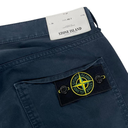 Stone Island navy blue trousers with RE-T fit, cotton material, and iconic compass logo.