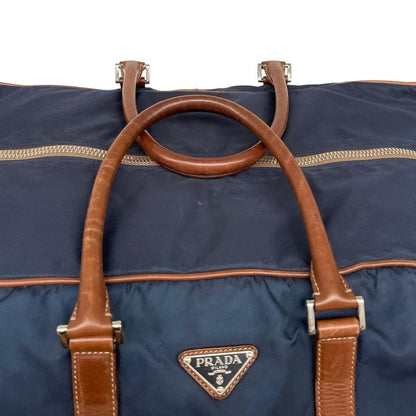 Prada navy blue and brown nylon duffel bag with signature logo and minimal wear.
