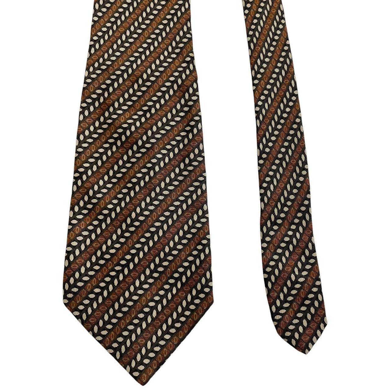 Coach brown floral print silk tie with intricate flower patterns and smooth texture.