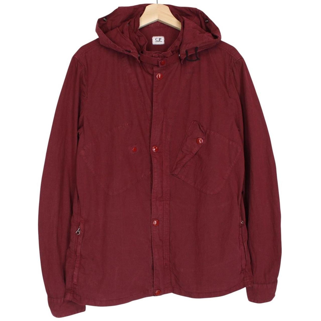 CP Company burgundy jacket with goggle detail and full zip closure.