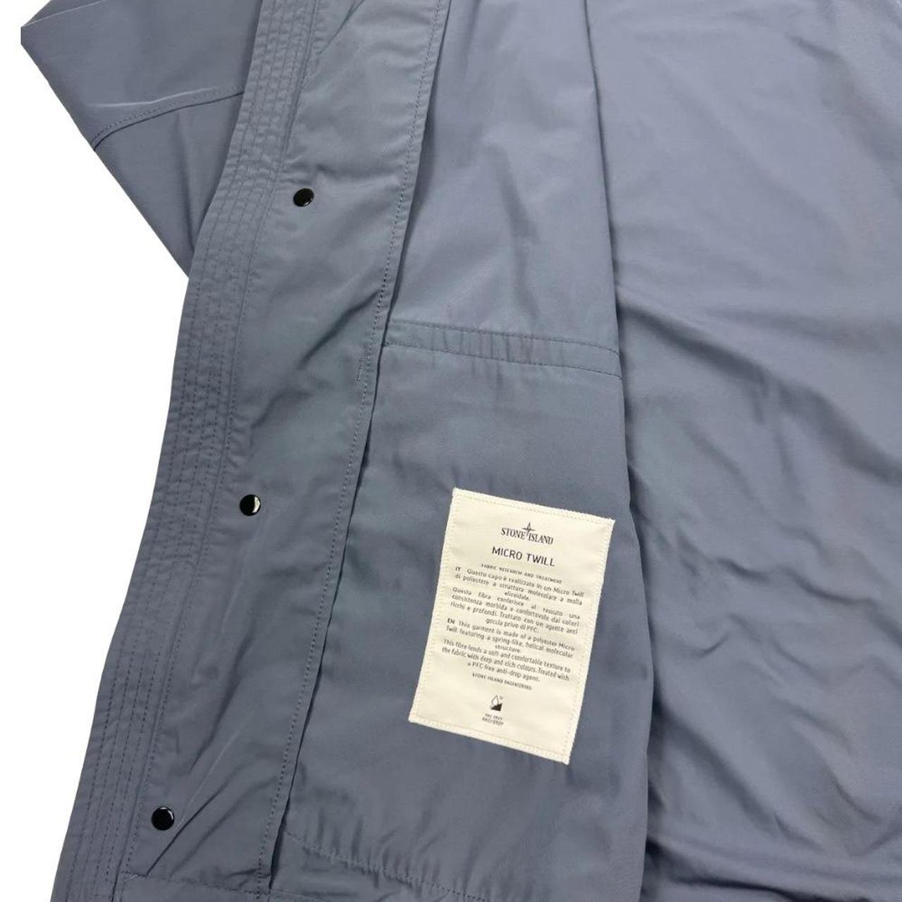 Stone Island blue hooded jacket with logo patch and micro twill fabric.