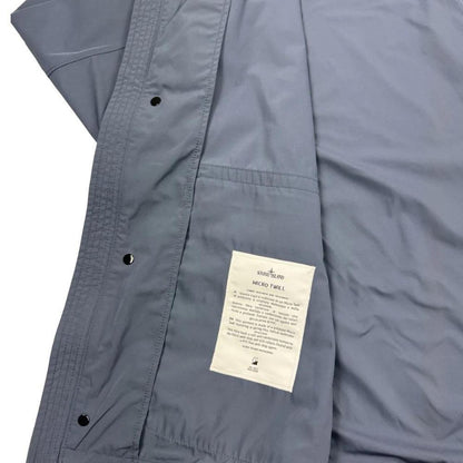Stone Island blue hooded jacket with logo patch and micro twill fabric.