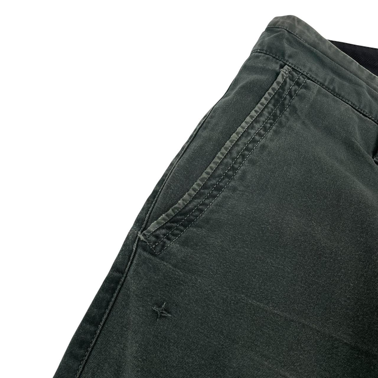 Stone Island green slim fit cotton trousers with logo patch and faded details.