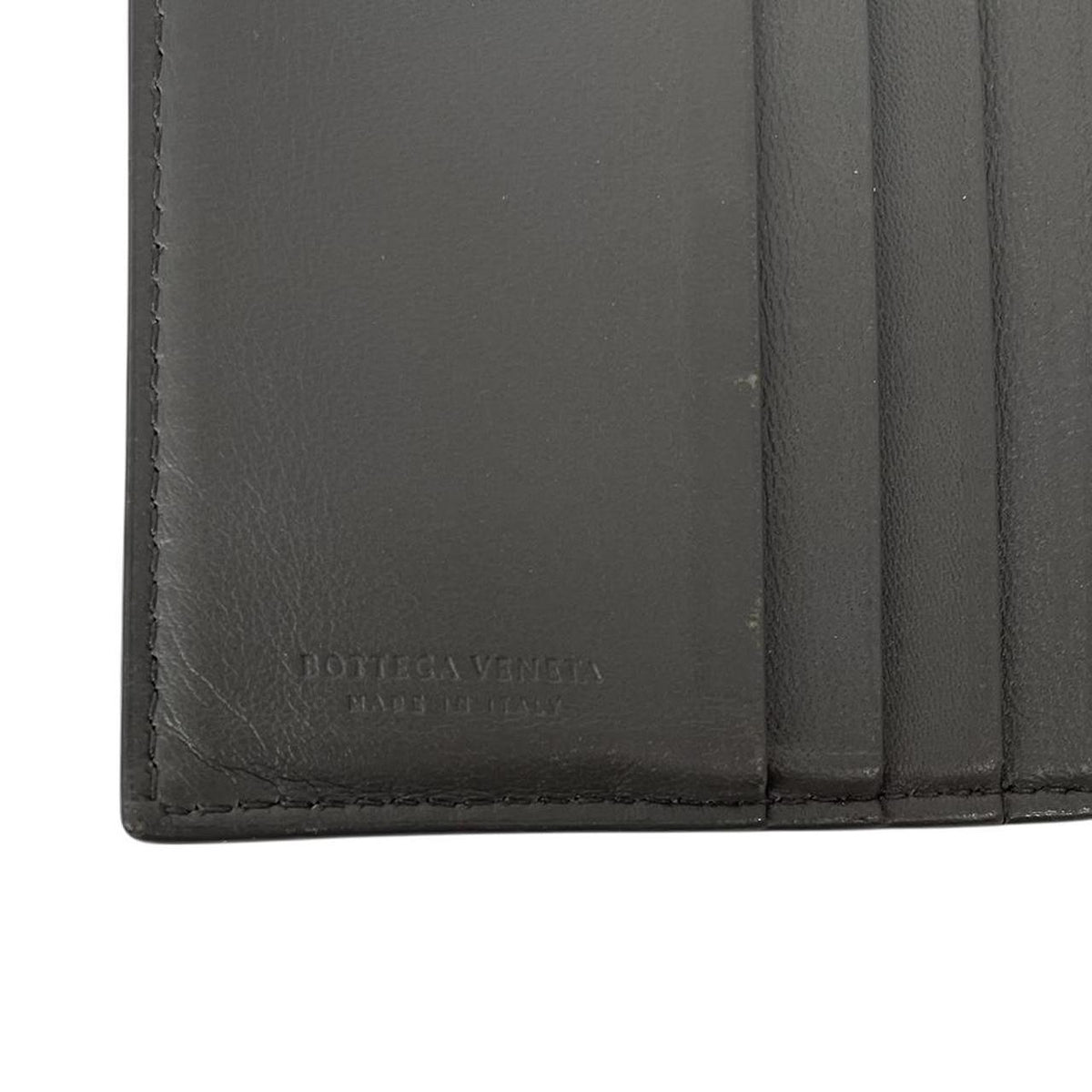 Bottega Veneta grey bifold wallet with Intrecciato woven leather pattern and popper closure.