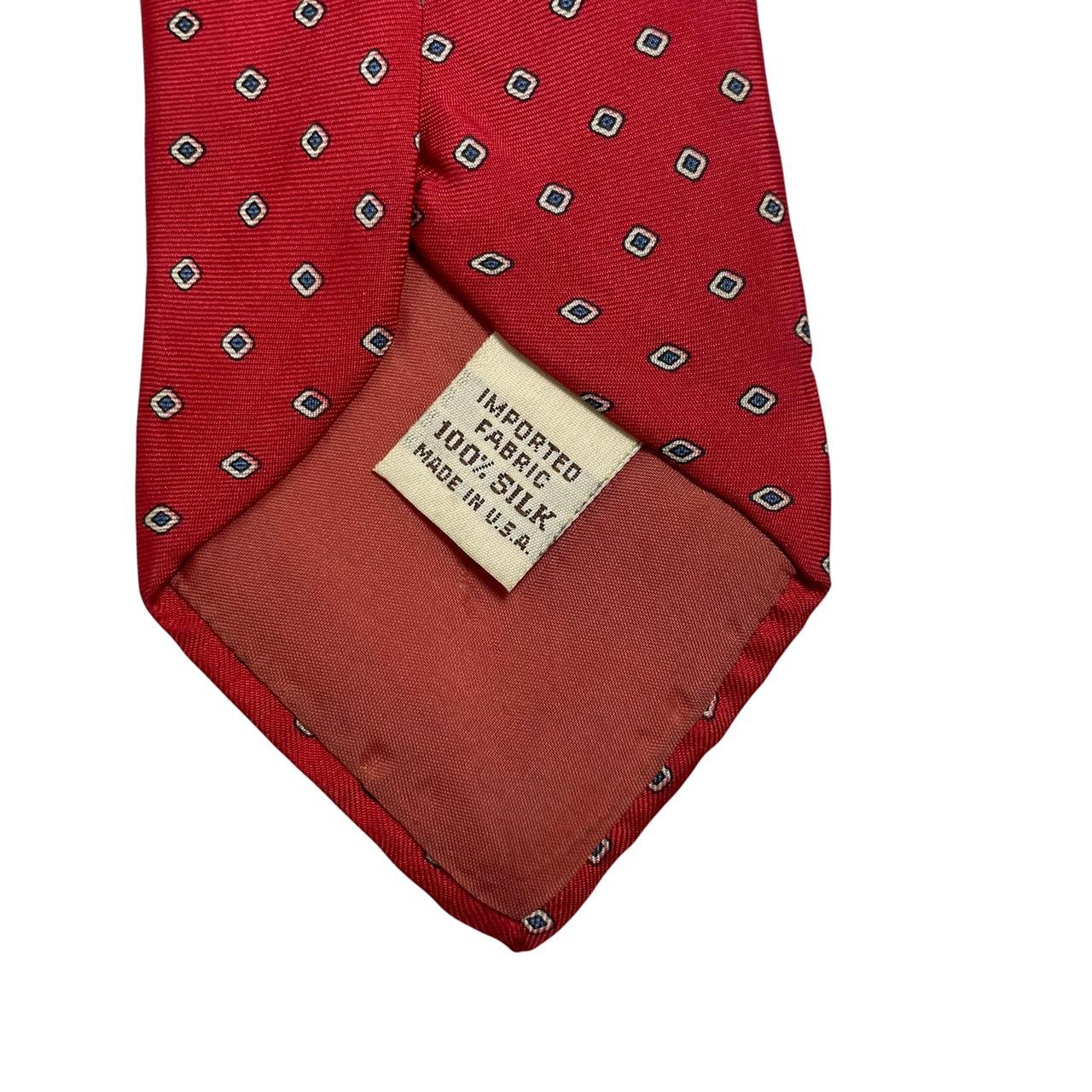 Yves Saint Laurent red silk tie with subtle sheen and vintage design.