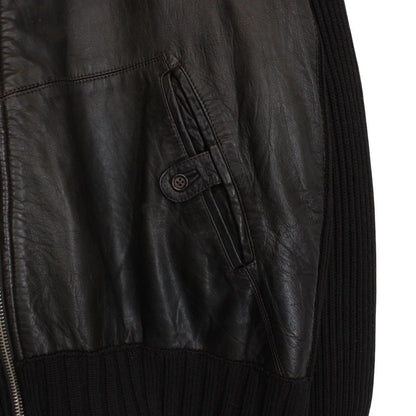 CP Company brown leather and wool shearling jacket with vintage design and logo details.