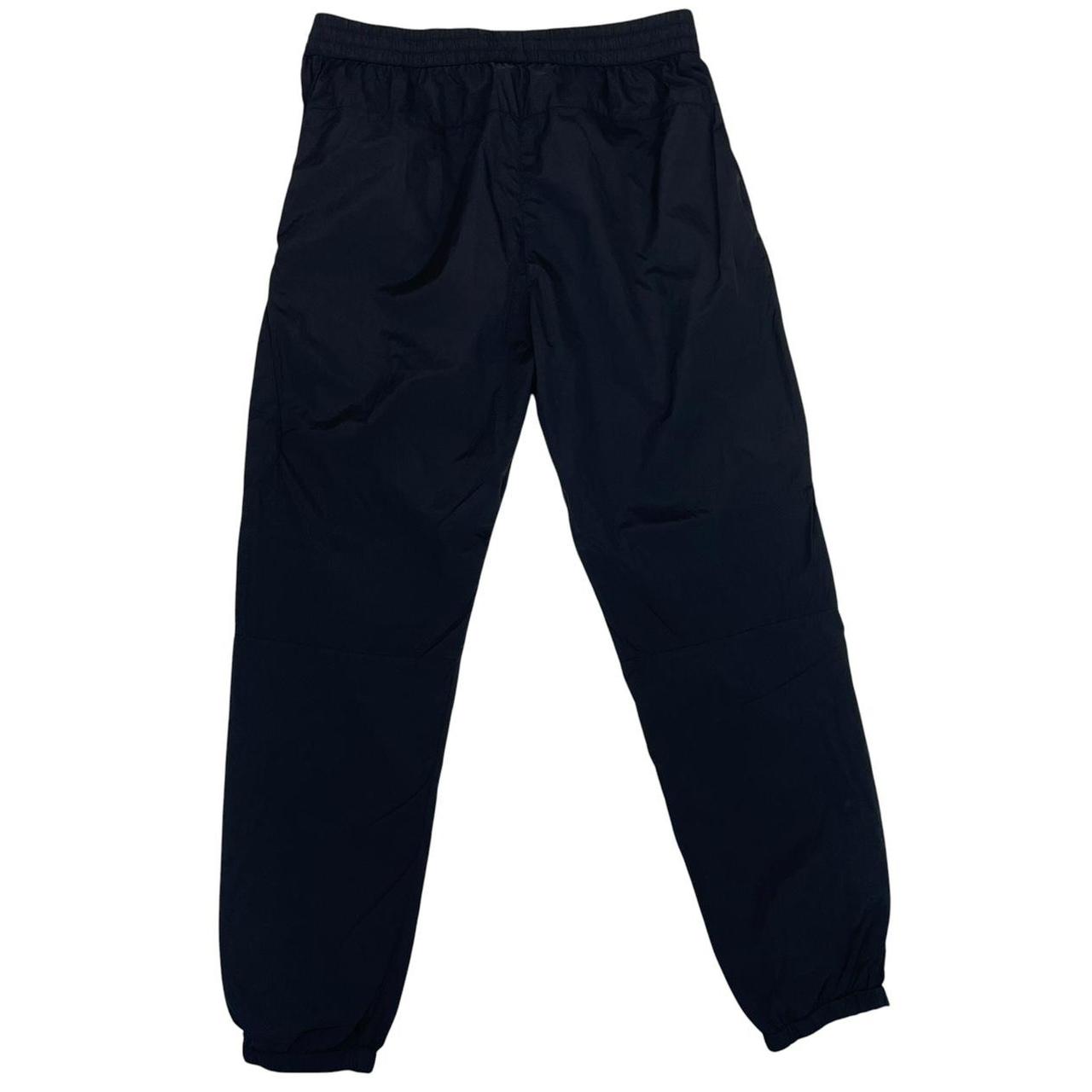 CP Company black cargo trousers with lens detail and nylon material.