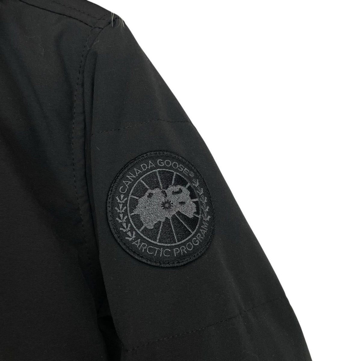 Canada Goose black parka with fur trim, logo patch, and down insulation.