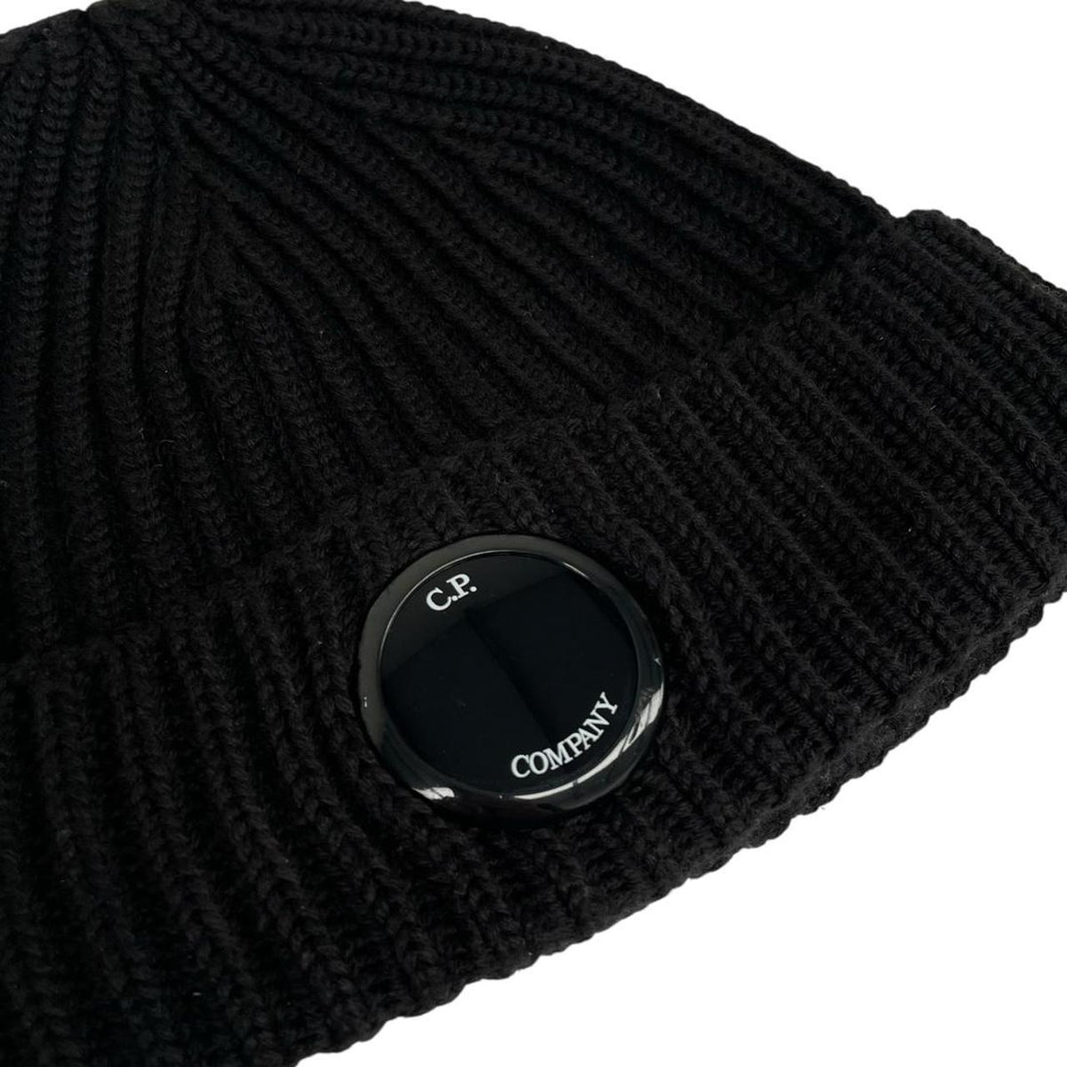 CP Company black wool knit beanie hat with signature lens detail.