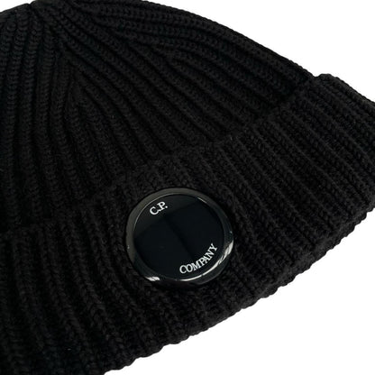 CP Company black wool knit beanie hat with signature lens detail.
