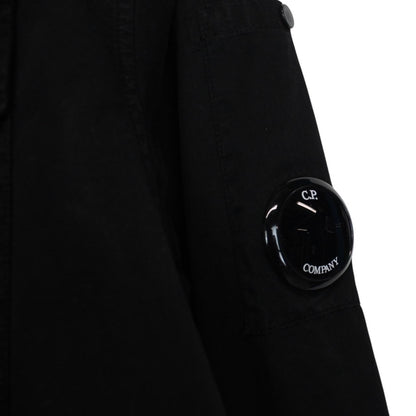 CP Company black button-up jacket with lens detail and cotton material.
