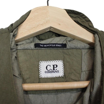 CP Company green hooded jacket with chrome detailing and logo patch on sleeve.