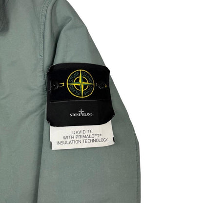 Stone Island green jacket with Primaloft insulation and iconic compass logo.