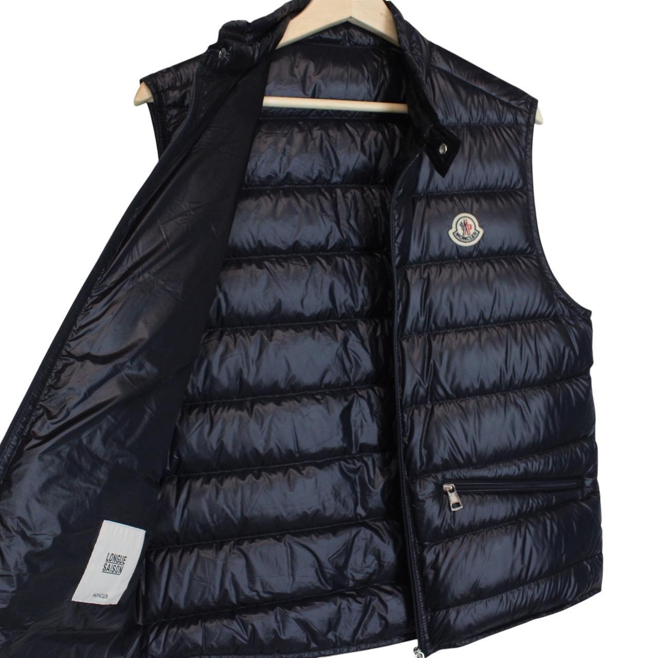 Moncler navy blue down gilet with logo patch and quilted design.