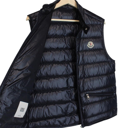 Moncler navy blue down gilet with logo patch and quilted design.
