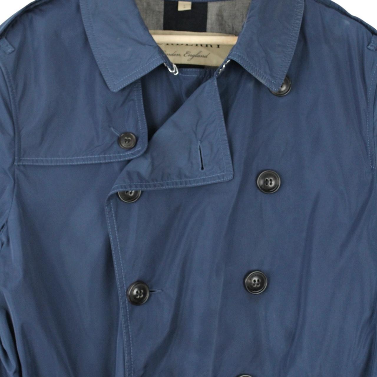 Burberry blue trench coat with Nova Check lining and belted double-breasted design.