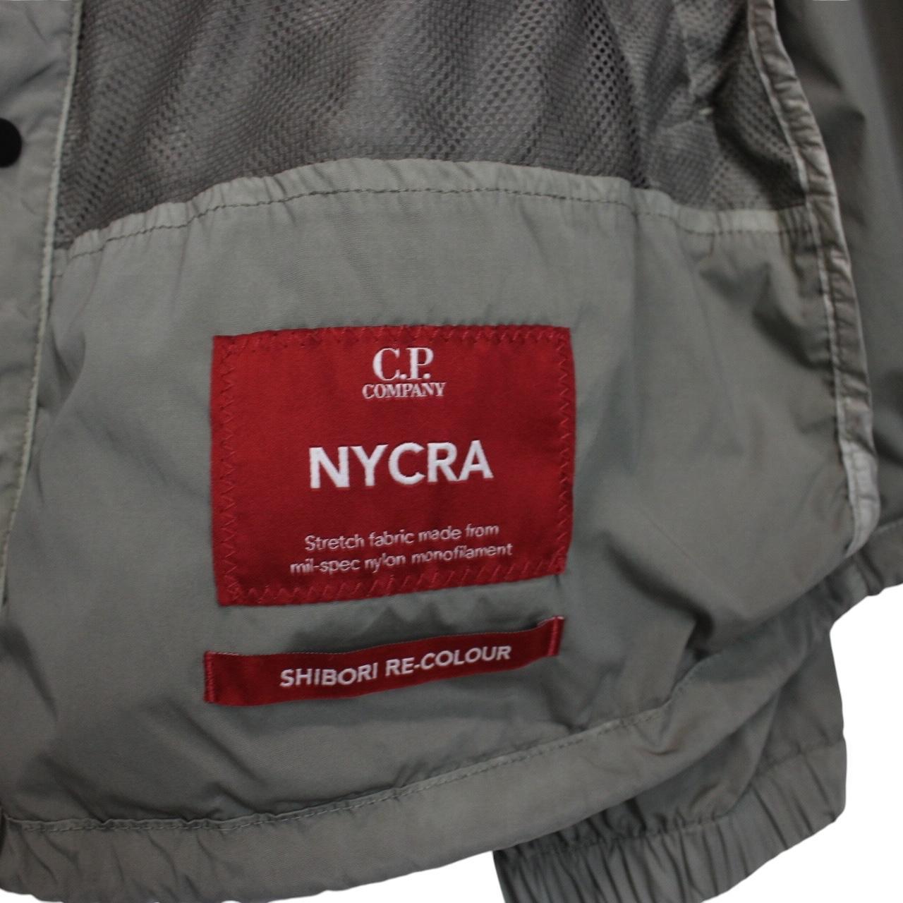 CP Company khaki green and grey jacket with shibori pattern and lens detail.