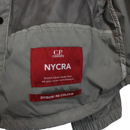 CP Company khaki green and grey jacket with shibori pattern and lens detail.