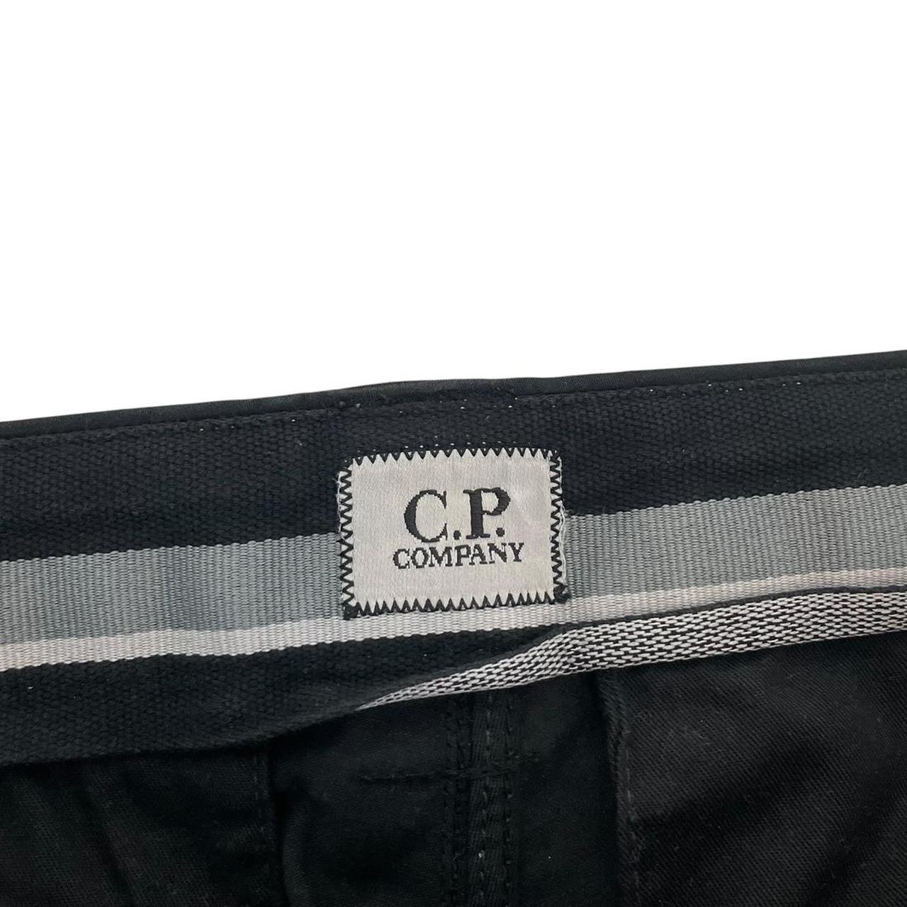 CP Company navy blue tapered fit cargo trousers with lens detail and pockets.
