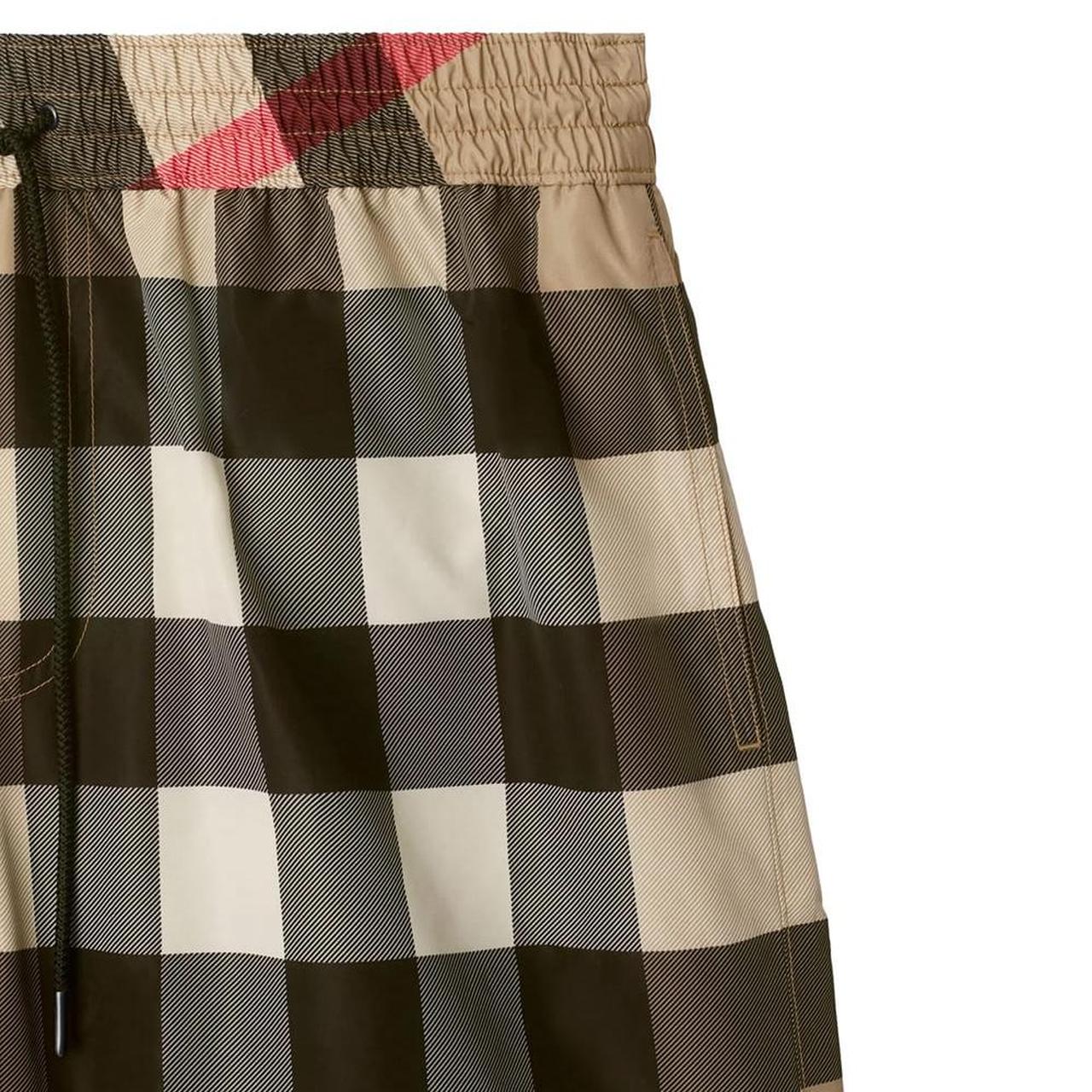 Burberry beige swim shorts featuring Nova Check pattern and nylon material.