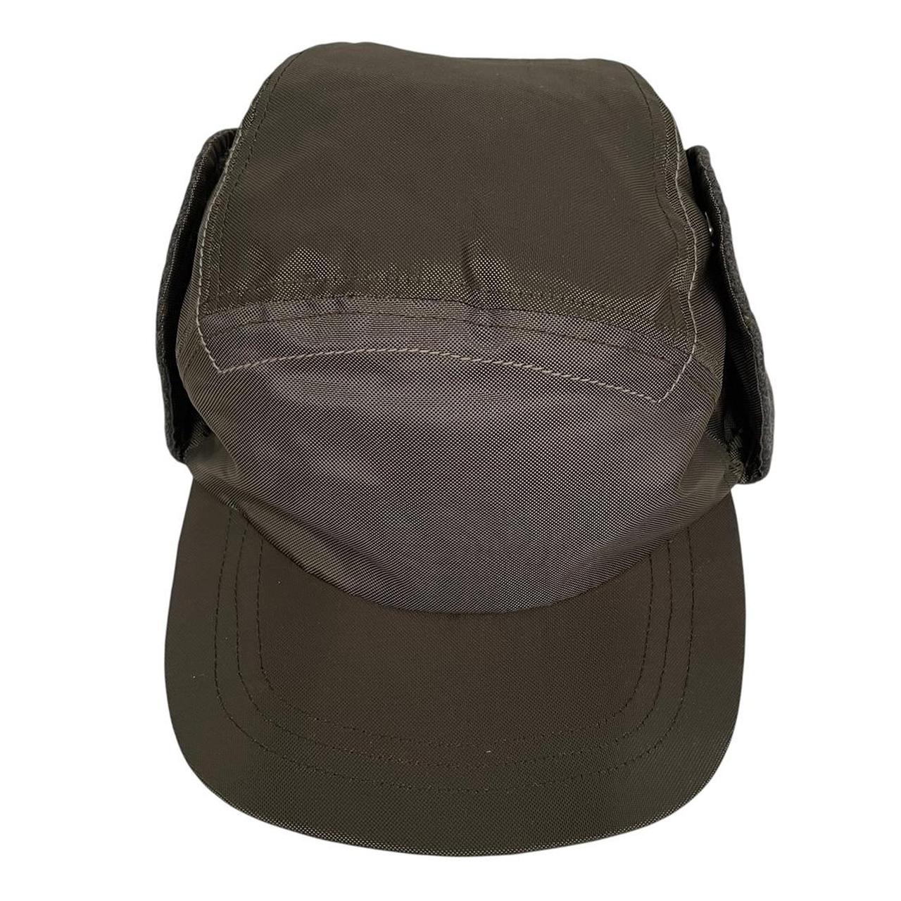 Paul Smith khaki green nylon ear-flap cap with logo detail and adjustable straps.