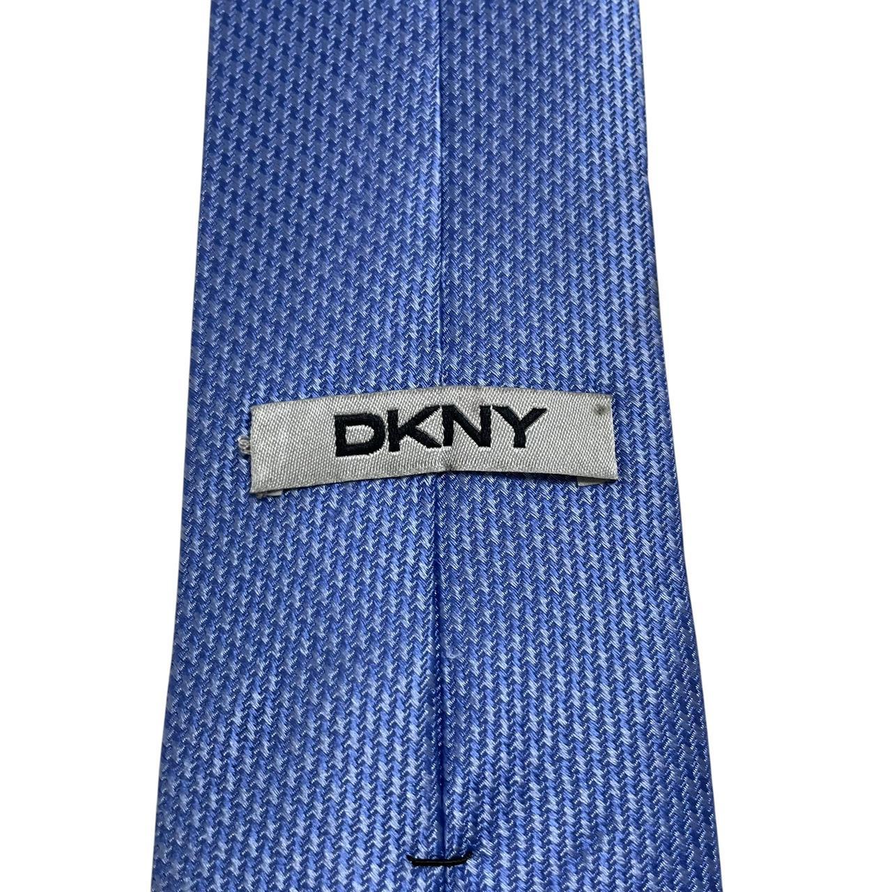DKNY blue silk tie with subtle sheen and classic design.