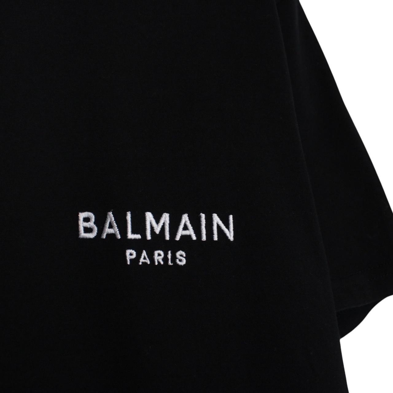 Balmain black pocket t-shirt with white embroidered logo and short sleeves.