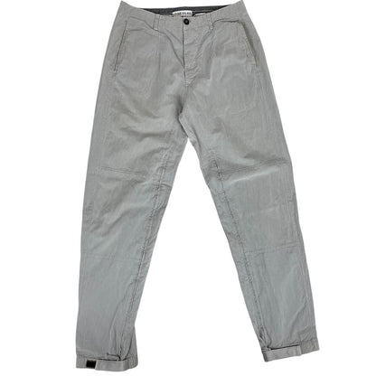 Stone Island grey tapered fit trousers with logo patch and cotton material.