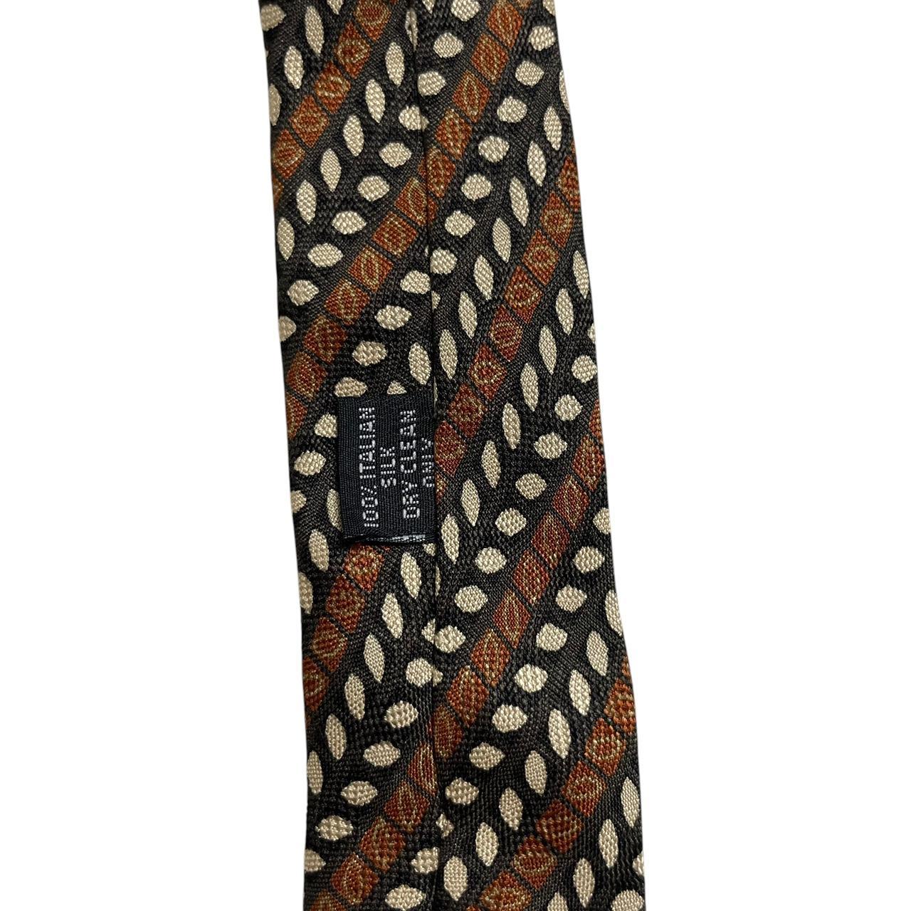 Coach brown floral print silk tie with intricate flower patterns and smooth texture.