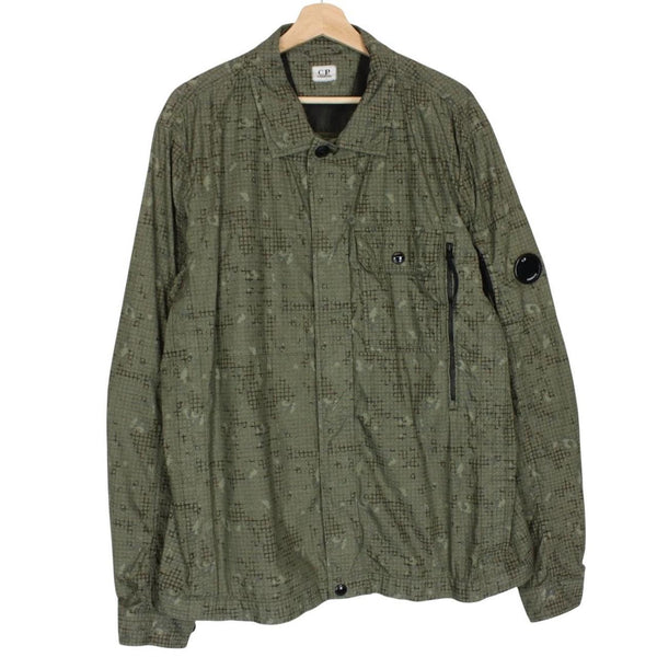 CP Company khaki green overshirt jacket with digital camouflage pattern and lens detail.